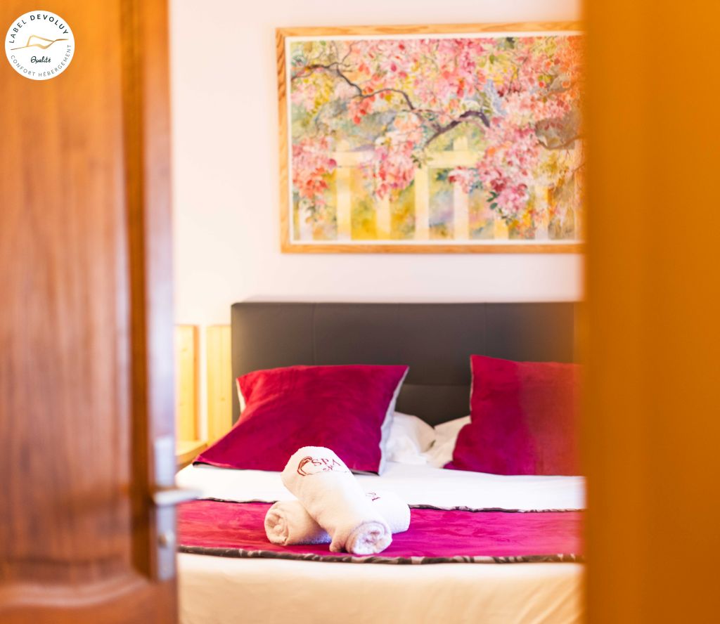 Chambre confort, tableau cerisier en fleurs et coussins framboise
